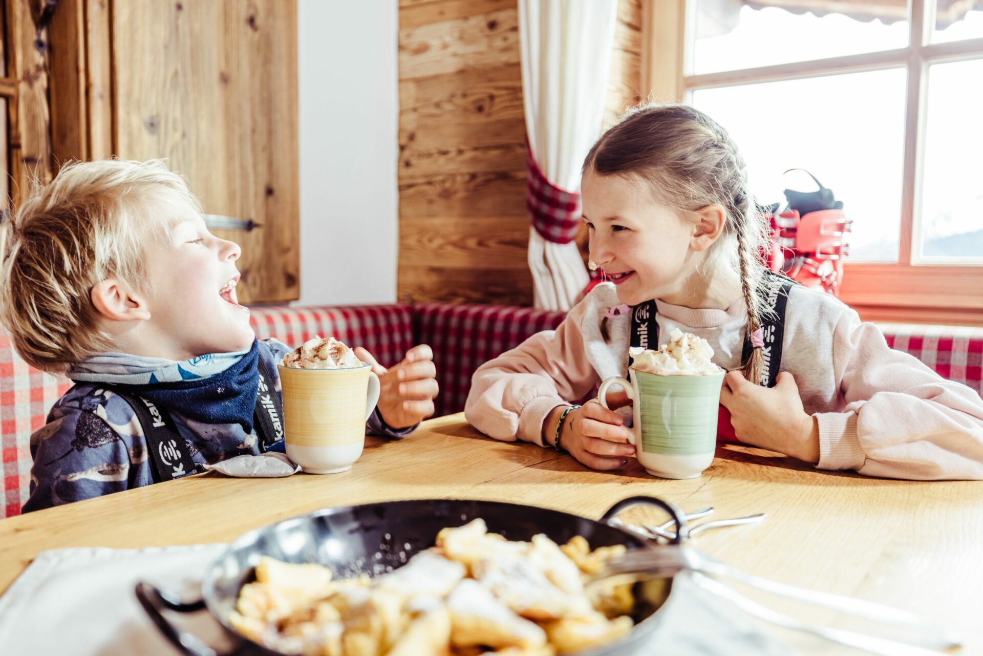 Zwei Kinder vergnügen sich an einem Tisch in einem Restaurant.