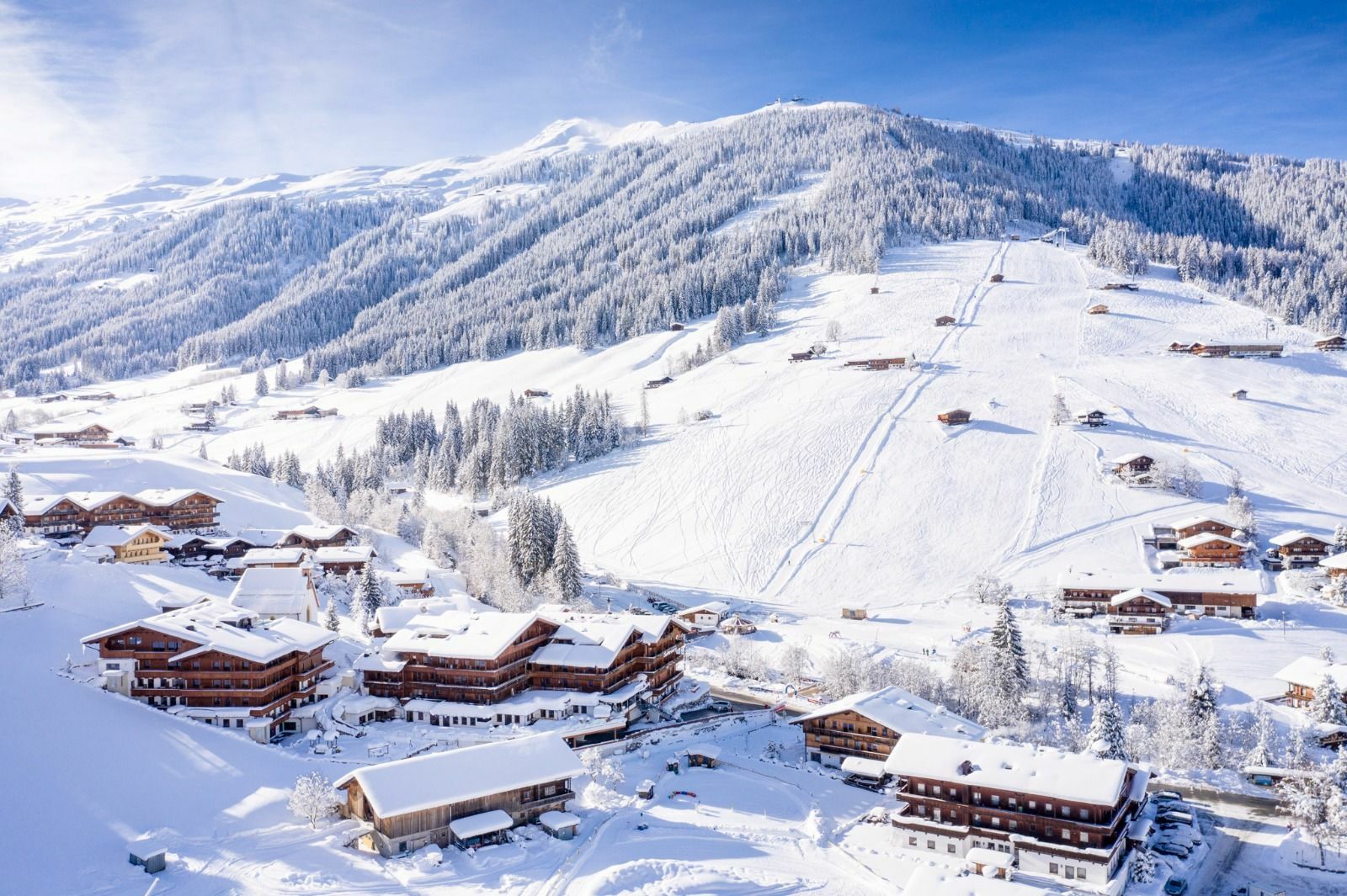 Luftaufnahme eines verschneiten Dorfes im Winter in Österreich.